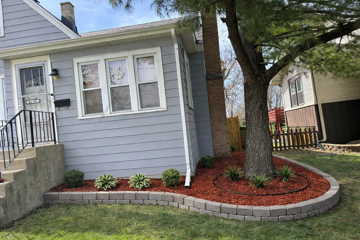 Beautiful front home retaining wall with mulch installation